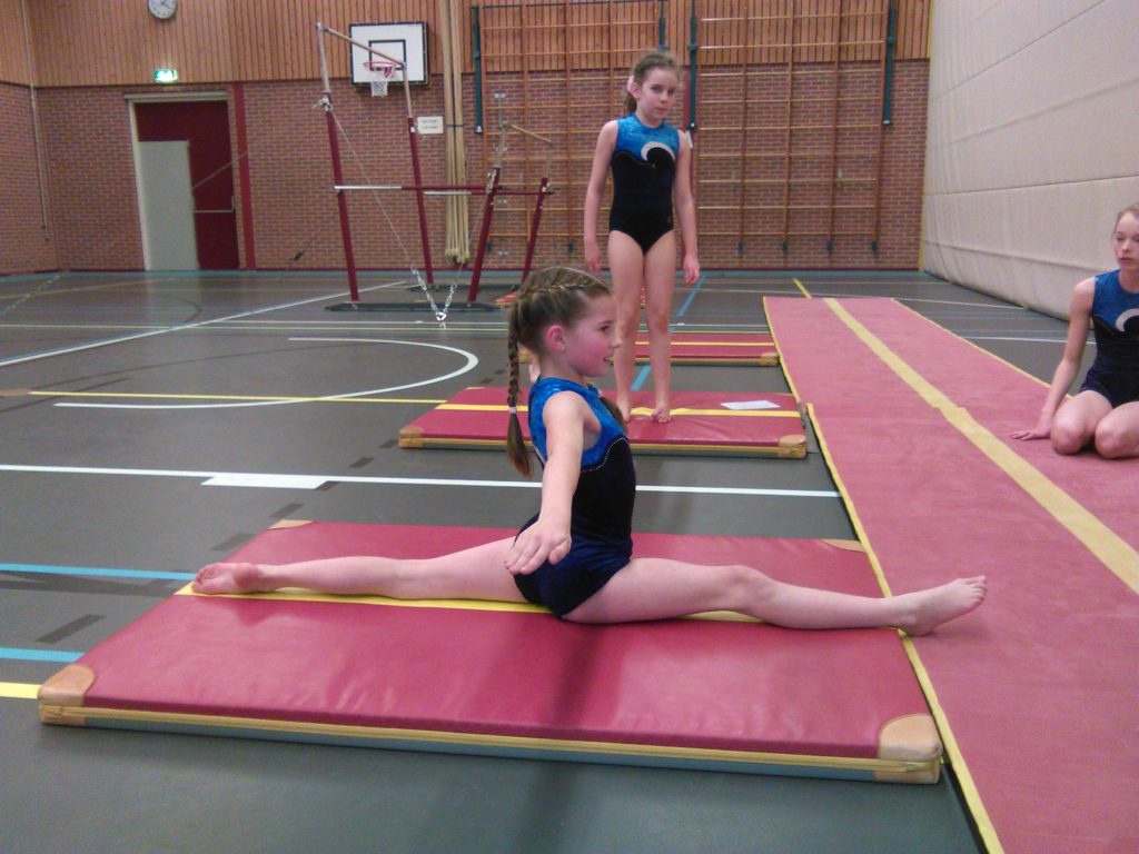 Gymnasten oefenen samen tijdens een turnles